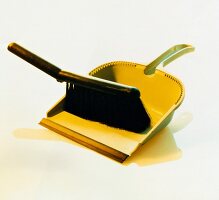 Hand brush and yellow dustpan on white background