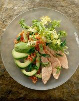 Close-up of frisee lettuce with avocado, salmon fillet and red lentils on plate