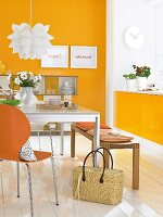 Essplatz mit orangefarbener Wand Sitzbank und Esstisch
