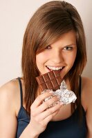 Magdalena Frau mit langen Haaren isst Tafel Schokolade