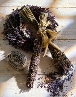 Close-up of lavender wreath and bunch of lavender with cord on wooden surface