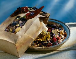 Close-up of dried flowers and oil bottle in paper bag and bowl