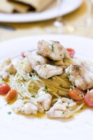 Close-up of pasta with grouper fish and cherry tomatoes on plate