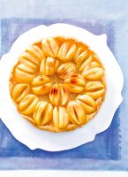 Apple puff pastry tart on cake plate, overhead view