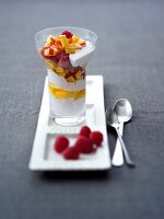 Yogurt with fruits in glass with raspberries on serving tray