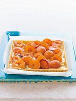 Apricot tart with vanilla cream on baking paper