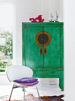 Green, wooden Chinese wedding cabinet and white shell chair