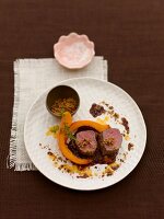 Grilled venison with cocoa beans and spiced crumbs on plate