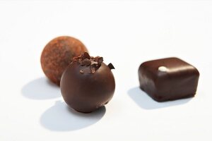 Close-up of round and square shaped chocolates on white background