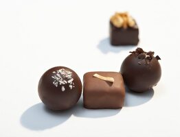 Four different types of chocolates with nuts on white background