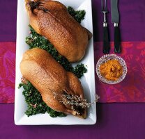 Two roasted goose with kale on plate