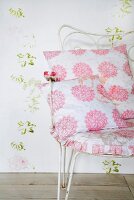 Pink and white floral patterned cushions on metal chair