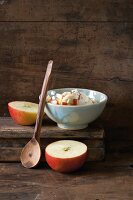 Apple with cinnamon and yogurt in bowl, halved apple