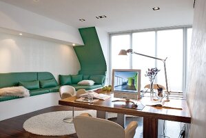 Bright office with desk and PC and green seating area