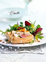 Close-up of fig tarts with goat cheese and winter salad on plate