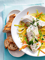 Close-up of fish fillet in saffron wine broth on plate