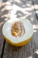 Halved honeydew melon on wooden surface
