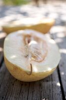 Halved melon blanc on wooden surface