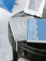 Blaues Buch m. Spitzenbordüre auf kleinem Beistelltisch