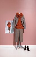 Loop collared sweater, brown coat and pants on clothes stand with photo of fashion model