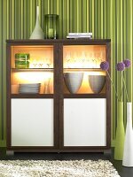 Wooden cabinet with glass doors, glasses and stack of plates