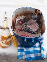 Braised leg of lamb with sour cherries in cooking pot