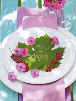 Menu for Anna written on one plate with flowers and berries