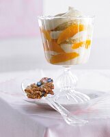 Orange and almond trifle with custard cream, oranges and biscuits in ice cream bowl