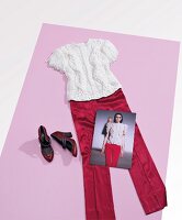 Red pants, white knit sweater and shoes on pink carpet