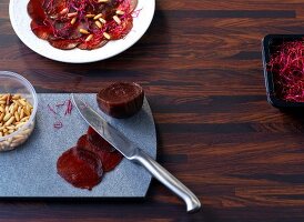 Beetroot on chopping board with knife and pine nut shell