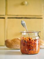 Sea buckthorn chutney in a preserving jar with a spoon in it