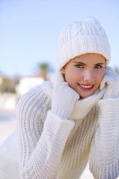 Portrait of pretty woman hair wearing white winter sweater, smiling