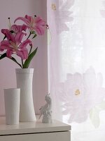 Rosa Lilie in weißer Porzellanvase auf Kommode, Porzellanvogel, weiß