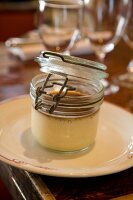 Crème caramel im Einweckglas ser- viert auf 1 Teller