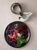 Bowl of red cabbage salad with sprouts and sauces