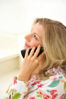 Beautiful blonde woman looking up while talking on the phone 
