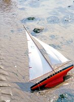 Close-up of toy sail boat in sand