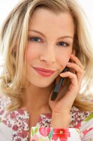 Close-up of beautiful blonde woman talking on phone, smiling