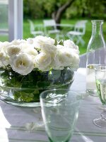 White roses in a round glass vase