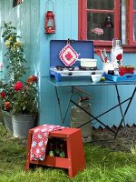 Campingkocher auf Tisch im Garten, blau-rot