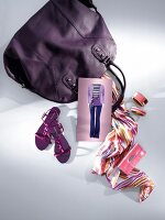 Two bags with gloves, scarf, necklace and shoes in purple on white background