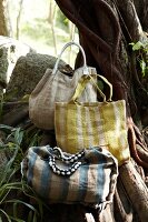 Three yellow, blue and grey striped jute bag on tree