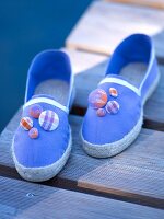 Close-up of pair of blue espadrilles decorated with sewed button