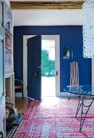 Eingangshalle, Tür offen, Wände blau Teppich, Kamin, Glasleuchter