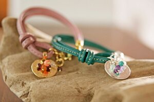 Close-up of pink and turquoise leather bracelets with pearls