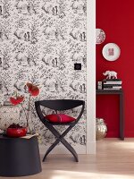 Stuhl schwarz mit Kissen vor Wand, Tapete gemustert, asiatisch