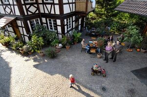 People sitting in courtyard in front of half timbered house