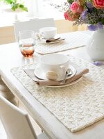 Place setting in creme on knitted placemat