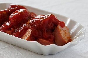 Currywurst in serving dish