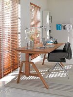 Office with wooden table, chair and wooden blinds on window
